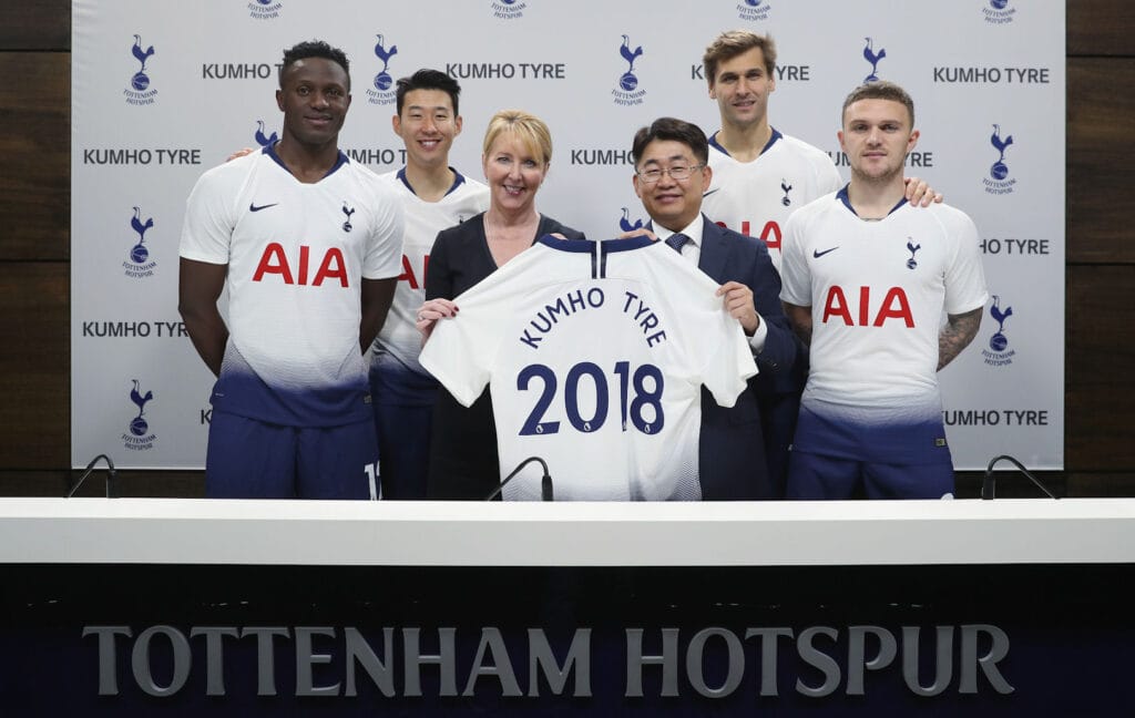 Donna-Maria Cullen holds a personalised Spurs jersey alongside Tottenham Hotspur players at the stadium